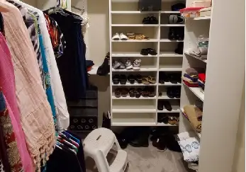 Small white closet full of items.