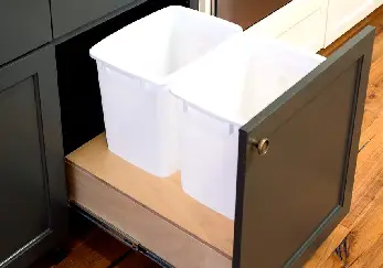 White trashcans in pull-out drawer.