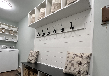 Bench area with hook and storage above in laundry room.