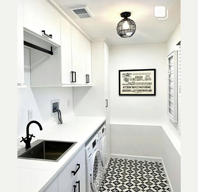 White laundry room with black sink.