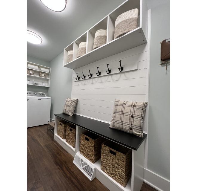 Laundry room with bench and cabinet storage.