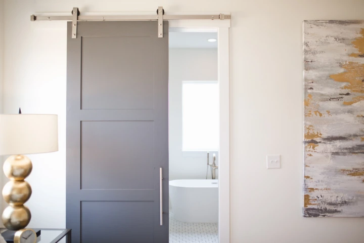 gray sliding door with metal mechanism opening to show modern white bathroom for Small bathroom design ideas