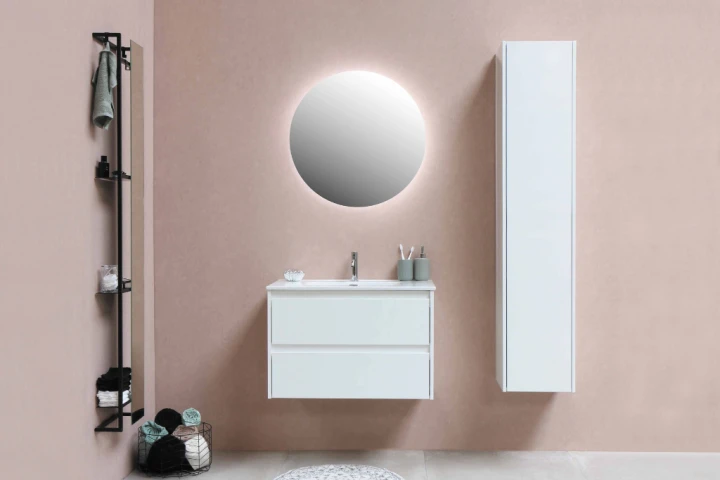 floating white bathroom cabinets on a blush wall with a round illuminated mirror