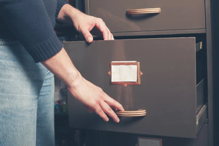 a person opening a file cabinet.