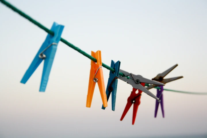 a group of clothes pegs on a rope.