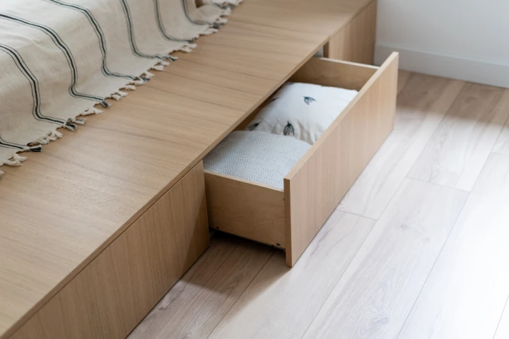 Storage under the bed by way of high bed frame or built-in drawers is ideal for maximizing storage solutions in a small guest bedroom.
