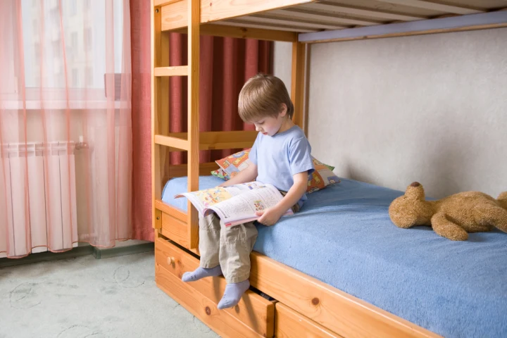 Boy on wood bunk bed for storage ideas for small spaces.