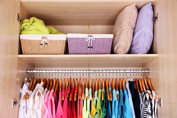 A closet with clothes and baskets.