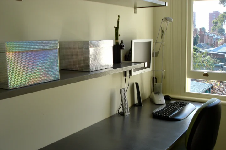 A desk with a computer and a keyboard.