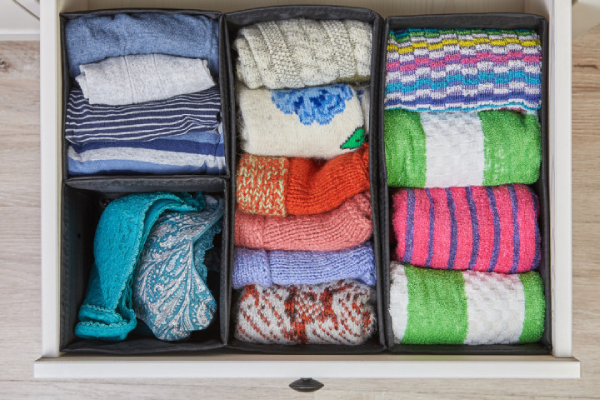 A drawer with different clothes in it.