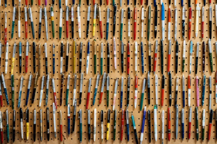 A group of pens on a peg board.