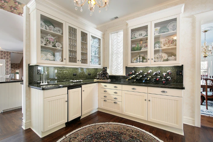 a kitchen with white cabinets and black counter tops