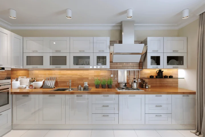 A kitchen with white cabinets and wood counter tops