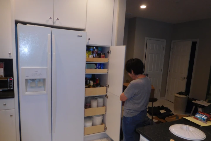 A person opening a cabinet.
