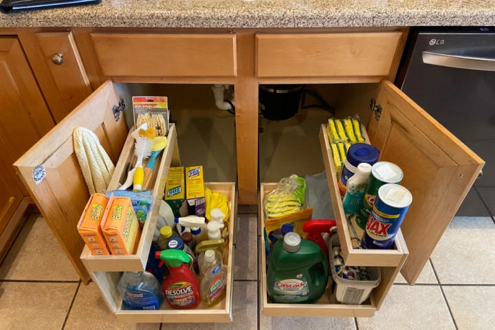 A shelf with a variety of cleaning supplies.