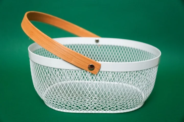 A white basket with a wooden handle.