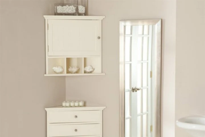 A white corner cabinet and a mirror.