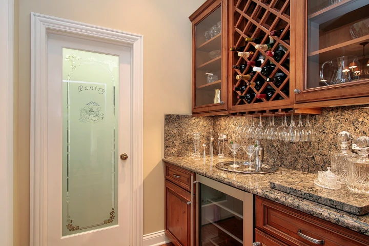 a wine rack with wine glasses in a kitchen.