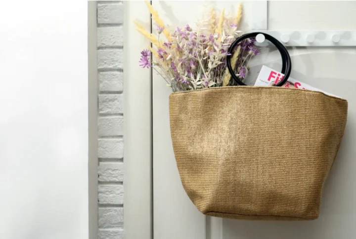 bag filled with flowers and magazines on a wall hanger.