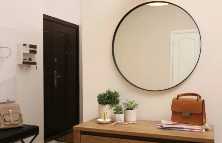 front entrance of an apartment with a mirror and dresser.
