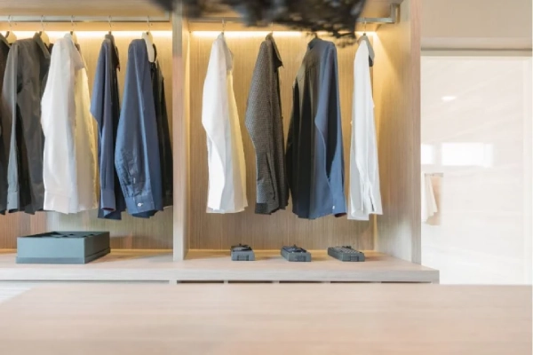 Clothes hanging in wooden walk in closet.
