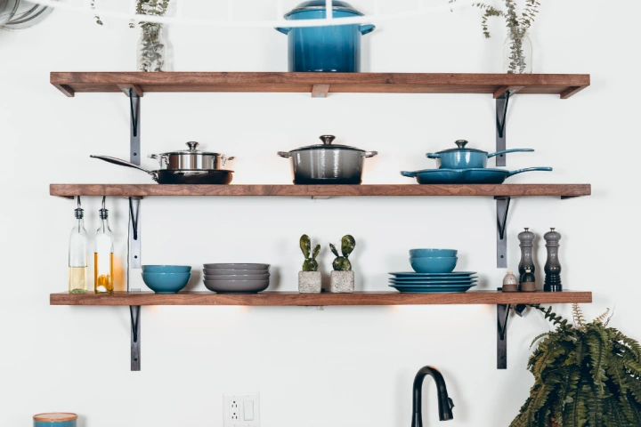 Floating shelves with pots and pans and other kitchenware.