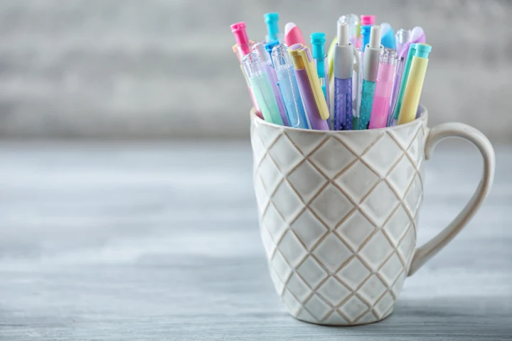 Ceramic cup filled with colored pens and reuse them for home office storage ideas.