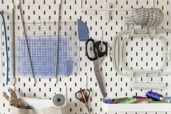 White pegboard with crafting materials.