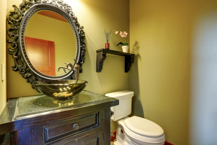 Bronze bathroom with Grecian mirror.