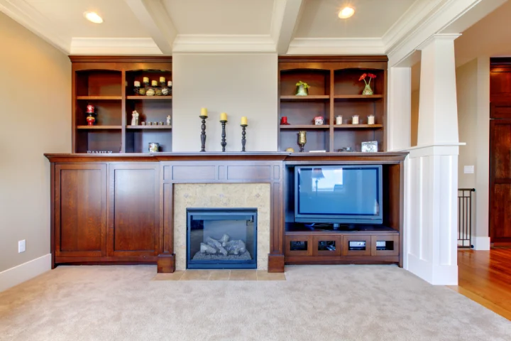 Custom-built shelving is ideal for creating storage under a TV when there’s a fireplace as the centerpiece of the room.