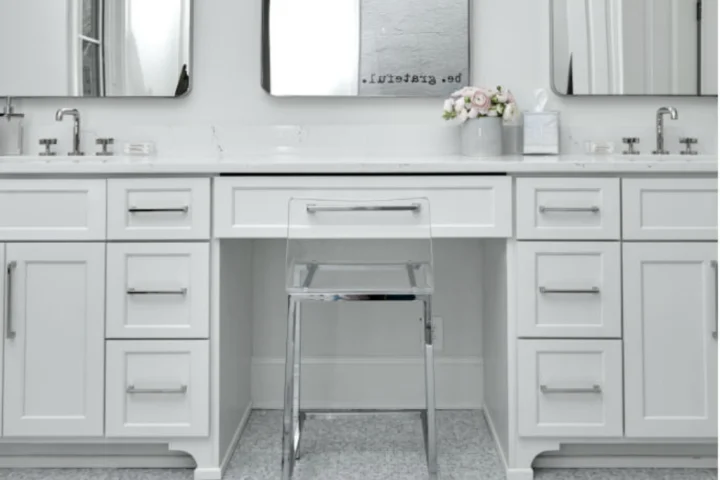 wide bathroom vanity with a chair and mirror.